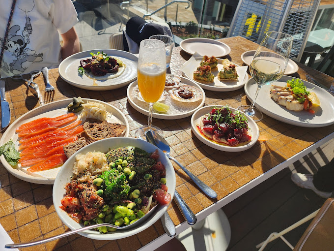 An assortment of vibrant dishes is served at an outdoor dining area, showcasing the diverse and delicious dining options available in Bondi Beach.