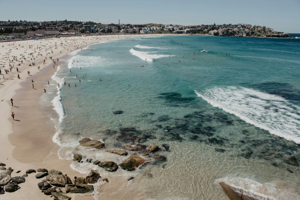 Aerial view of Bondi Beach with swimmers and sunbathers, highlighting popular activities at one of Sydney’s best beaches.