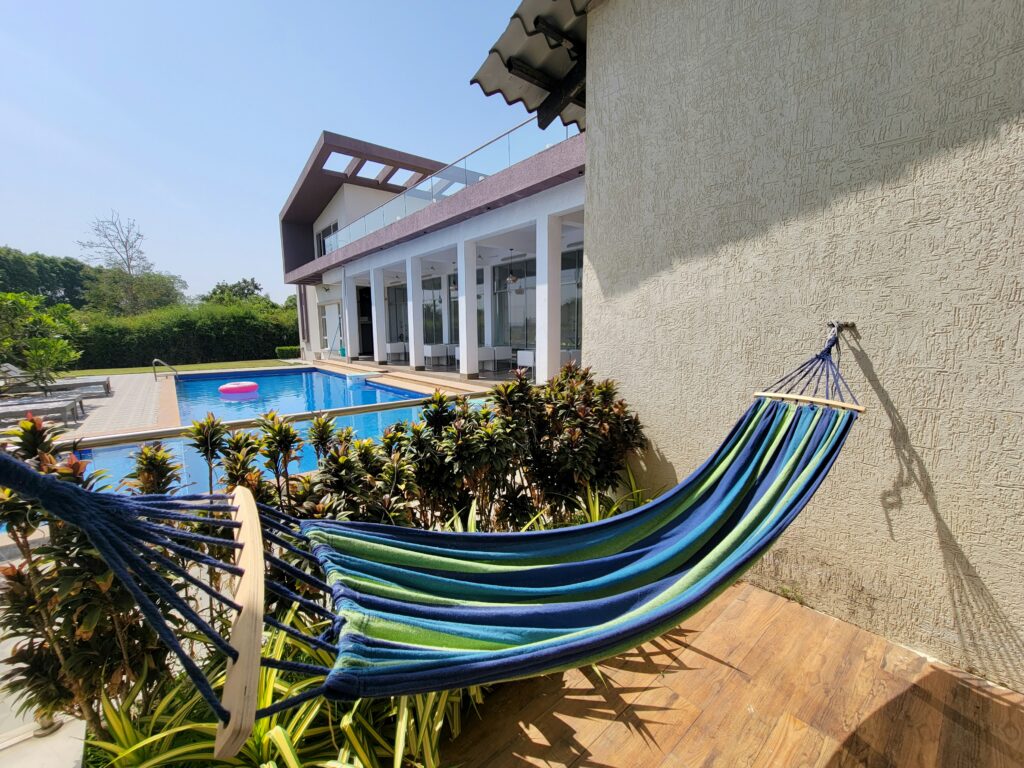 Outdoor hammock overlooking a private pool area, showcasing unique Airbnb amenities that enhance a relaxing stay experience compared to hotels.